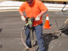 A worker is shown operating a jack-hammer.