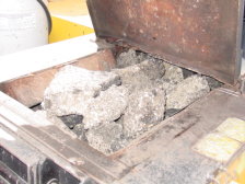 Asphalt chunks are shown in the recycler's hopper.